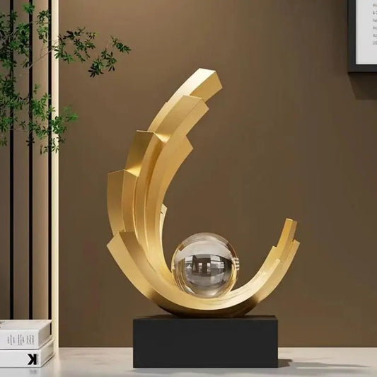 Escultura Dorada con Esfera de Cristal